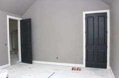 an empty room with two black doors in it