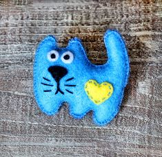 a blue felt cat with a yellow heart on it