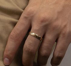 a man's hand with a gold ring on it