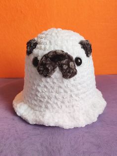 there is a white crocheted hat with a pug face on it