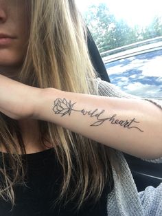 a woman with a tattoo on her arm that says world heart in cursive writing