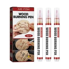 three wooden burning pens in front of a box with two different designs on them