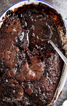 a chocolate cake in a blue and white bowl with a spoon sticking out of it