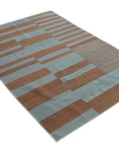 a brown and blue area rug with squares on the top, in front of a white background