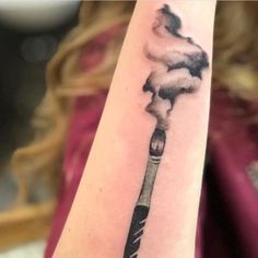 a woman's arm with a black and white ink drawing of a smokestack on it