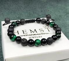 Are you looking for a unique accessory that will not only highlight your style but also bring good luck? We present you our magnificent bracelet made of natural stones: agate, lava stone and tiger's eye in green. This bracelet will be a perfect addition to both everyday and evening looks. Material: Agate, Lava and Tiger's eye stones. Color: black and green. Stone diameter: 8 mm. Base: nylon cord. This model of the bracelet is tightened, so there is an option to adjust the size. Model: unisex. Packaging: perfectly packed in a branded box, perfect as a gift. Key features: Natural stones: The bracelet is made of agate, lava stone and tiger's eye, each of which has unique properties. Agate is known for its ability to bring harmony and tranquility, and tiger's eye - to protect from negative ene Agate Gemstone Beaded Bracelets As Gift, Green Agate Bracelets For Gifts, Agate Bracelets With Natural Stones As Gift, Agate Bracelets As A Gift, Hand-strung Agate Crystal Bracelet As Gift, Round Agate Bracelet Gift, Adjustable Agate Beaded Bracelets As Gift, Casual Crystal Bracelet With Natural Stones For Gift, Casual Crystal Bracelet With Natural Stones As A Gift