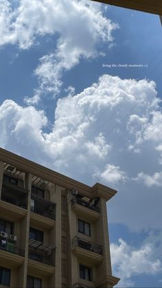 an apartment building under a cloudy blue sky