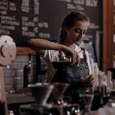 a woman pouring coffee into a cup