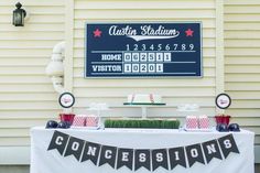 a table topped with cake and desserts next to a sign