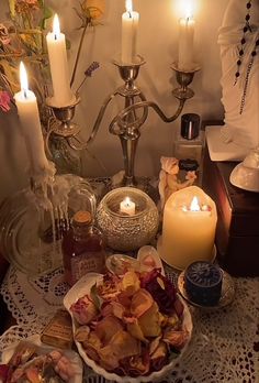 a table topped with candles and plates filled with food on top of a doily