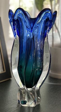 a blue glass vase sitting on top of a table