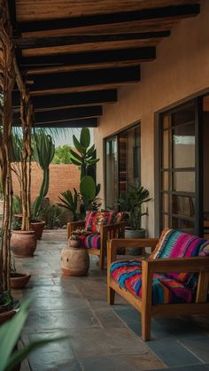 an outdoor patio with chairs and potted plants