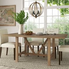 a dining room table with chairs and a potted plant