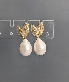 "Baroque Pearl Gold Leaf Stud Earrings, Teardrop Pearl Earrings, Bridesmaid Earrings, Wedding Earrings, June Birthstone, which measure approx. 10x15mm.   These earrings measure approx. 1.1\" ( 27 mm.)  Nice jewelry gift.  * Processing time is 3 - 5 days.  * US orders are shipped first class mail. * International orders are shipped first class international. * Shipping upgrades are available at checkout. Thank you for visiting GlamorousJewelry1" Handmade Elegant Teardrop Earrings For Anniversary, Elegant Handmade Teardrop Earrings For Anniversary, Elegant Gold Pear-shaped Drop, Elegant Teardrop Crown Matching Earrings Jewelry, Elegant Jewelry With Matching Teardrop Crown Earrings, Elegant Jewelry With Teardrop Crown Matching Earrings, Clip-on Teardrop Pearl Jewelry, Teardrop Pearl Clip-on Jewelry, Teardrop Pearl Clip-on Earrings