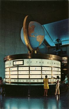 people standing in front of a building with a globe on top