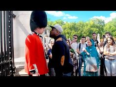 two men are talking to each other in front of a group of people standing outside