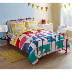 a bed room with a neatly made bed and colorful comforter on top of it