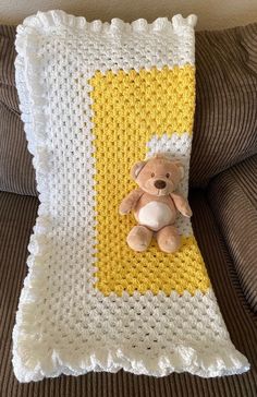 a crocheted blanket with a teddy bear on it