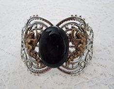 "This beautiful bracelet has a silver plated cuff, silver plated chain, brass winged goddesses and a beautiful black agate stone. 7\" long can be adjusted to 9\" long. Silver plated lobster clasp." Gothic Art Nouveau, Black Agate Stone, Jewelry Victorian, Jewelry Gothic, Neo Victorian, Art Nouveau Art, Nouveau Art, Medieval Jewelry, Agate Bracelet