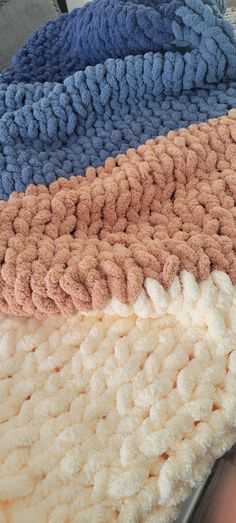 three different colors of blankets on top of each other in the same pattern and size