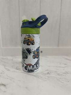 a green and blue sippy cup sitting on top of a counter