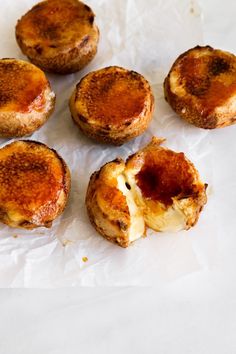 small pastries sitting on top of a piece of wax paper covered in brown sauce