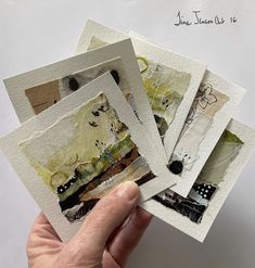 a hand holding up four different pictures on white paper