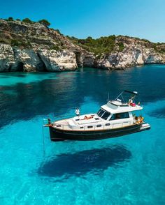 a boat is floating in the clear blue water