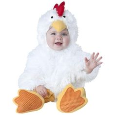 a baby in a chicken costume sitting on the ground with his hands out and smiling