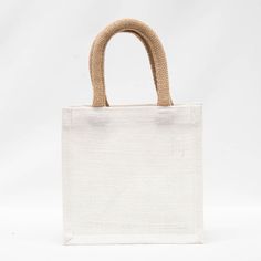 Ditch the plain paper bag this holiday season and upgrade to a petite jute gift tote. The white bag says "Joy" with a cute ornamented "O," and is the perfect size (7"x7"x5") for a typical coffee mug present. White Rectangular Gift Bag, Cream Rectangular Bag For Gift, Cream Rectangular Bag As A Gift, Rectangular Cream Bag As A Gift, Handmade White Bags For Gifts, Cream Tote Bag As A Gift, Rectangular Jute Bag For Gifts, Eco-friendly White Square Bag, White Jute Bags For Daily Use