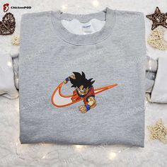 Introducing the ultimate fusion of style and fandom – the Goku x Nike Swoosh Anime Embroidered Tshirt. This Dragon Ball-inspired shirt combines the iconic Nike swoosh with Goku’s power-packed persona, creating a design that’s a must-have for any anime enthusiast. Crafted with meticulous attention to detail, the embroidered artwork brings Goku to life, showcasing his electrifying superpowers. Made from premium quality fabric, this shirt offers unrivaled comfort and durability, e Buu Dbz, Ethereal Realm, Nike Inspired, Goku And Chichi, Best Family Gifts, Hoodie Ideas, Maroon Hoodie, Embroidered Shirts, Balls Shirt