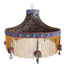 an animal print lamp shade with beads and chains hanging from it's center pole