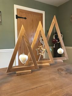 three wooden triangle ornaments sitting on top of a table next to each other in front of a door