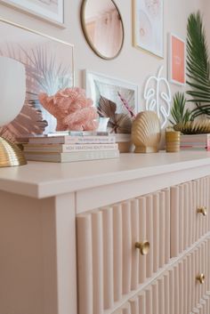 a white dresser topped with books and pictures