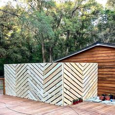 a wooden deck with potted plants on it and a fence in the back ground