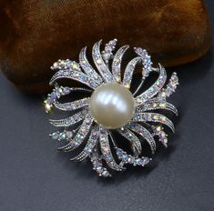 Vintage silver tone AB rhinestone faux pearl pin brooch pendant, In good vintage condition, It's 1"1/2 across. Thanks. Silver Pearl Brooch For Anniversary, Formal Silver Pearl Brooch, Silver Sparkling Brooches For Anniversary, Sparkling Silver Brooch For Anniversary, Silver Sparkling Brooch For Anniversary, Silver Rhinestone Round Brooches, Silver Brooch Pins For Costume Jewelry, Silver Costume Jewelry Pins Brooch, Silver Costume Jewelry Brooch Pins