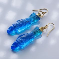 They look absolutely identical to Swedish Fish Gummy Candy, but they are hand crafted from Glass! Designed and created by Artist, and Head Designer of Local Art Glass, Evan Burnette, These earrings are a fun, playful, and an avant-garde fashion statement. They come in multiple flavors, and are available in 18 karat gold, some available in Argentium Silver. Current Flavors: Grape, Pineapple, Strawberry, Lime, Mystery Flavor, Peach, Watermelon, Pink Lemonade, Blue Raspberry, Tangerine *Return Policy We have very high-quality standards, however when things get busy something might slip by. If you receive something in which you feel might be a manufacturers error, please contact us immediately with a photo and we will either immediately send you a replacement or issue a full refund.  If you wi Blue Fish-shaped Earrings For Gift, Gift Blue Fish Hook Earrings, Blue Fish Hook Earrings For Gift, Gummy Fish, Strawberry Lime, Swedish Fish, Pineapple Strawberry, Fish Earrings, Fish Jewelry