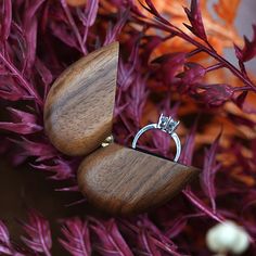 two wooden rings are sitting on some purple flowers