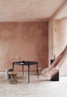 a table and chairs in a room with pink walls