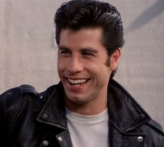 a smiling man wearing a black leather jacket