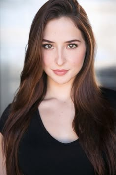 a woman with long brown hair posing for a photo