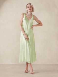 This floaty midi dress is cut with inset godet panels to increase the sweep of its skirt.  For fabric, we selected our signature silk charmeuse, a fabric we love for its beautiful drape, satin-like shine, and ease of care.  Trapeze Fit: Cut for a flowing, A-line fit.  No waist definition.  Scoop neck.  Scoop back.  Fully lined.  Trapeze Fit: Cut for a flowing, A-line fit.  No waist definition.  Sleeveless.  Midi length.  Model: Size S, 5'10" (178cm). Sea Green Dress Silk, Green Satin Dress With Cardigan, Floaty Midi Dress, Waist Definition Dress, Pickle Green Dress, Green Solk Dress, Floaty Maxi Dress, Silk Midi Dress, Silk Maxi Dress