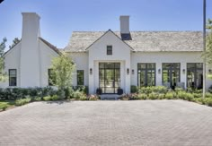 a large white house with two chimneys on the roof