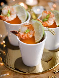 small cups filled with shrimp and garnished with lime