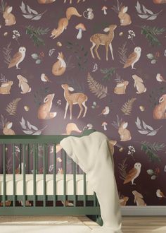 a baby's crib in front of a wallpaper with deers and leaves