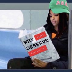 a woman sitting down reading a book with an aka hat on top of her head