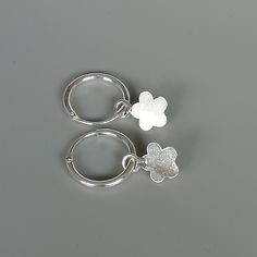 A PAIR of sterling silver hoops. Comes with a detachable cut out flower charm. The charm is multipurpose and can be used with a neck or bracelet chain too. Dimension: Hoop- 12 x 1.5 mm Charm: 7 x 11 mm Drop length- 21 mm These earrings are made of 925 hypoallergenic sterling silver and plastic. Please note this price is for ONE PAIR. All my pieces are sent in a gift box. I can include a personal message from you if needed You are welcome to contact me at... bhavnakwintra1956@gmail.com For more b Sterling Silver Flower Charm Earrings For Everyday, Sterling Silver Earrings With Flower Charm For Everyday, Small Hoop Jewelry With Flower Charm For Everyday, Small Hoop Jewelry With Flower Charm For Gifts, Everyday Small Hoop Jewelry With Flower Charm, Nickel-free Silver Huggie Earrings, Huggie Earrings With Flower Charm For Gift, Flower Charm Huggie Earrings As Gift, Gift Jewelry Flower Charm Huggie