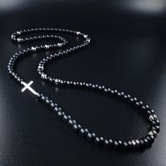 Mens cross rosary necklace gemstone Black onyx, Sterling silver cross chain necklace for men, Unique gifts for men - for him The Gnatus 78cm rosary necklace is made with midnight black Onyx and titanium steamed silver Hematite beads. Thoughtfully a 925 sterling silver cross have been placed sidewise which gives a unique finish to this necklace. Each stone is carefully selected and strung on stainless steel wire for maximum hold. Add boldness and charm to your neck with this unique gemstone rosar Black Sterling Silver Jewelry With 8mm Beads, Silver Cross Jewelry With 8mm Beads, Elegant Black Cross Necklace Gift, Minimalist Black Cross Jewelry, Onyx Cross Jewelry As A Gift, Silver Cross Jewelry With Black Beads, Crucifix Jewelry With Black Beads As Gift, Minimalist Black Cross Pendant Necklace, Minimalist Black Cross Pendant Jewelry