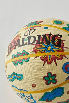 a close up of a basketball on a white surface with colorful designs and words painted all over it