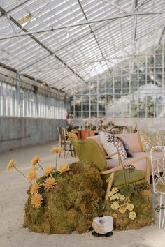 an outdoor seating area with chairs and tables covered in hay, plants and flowers on the ground